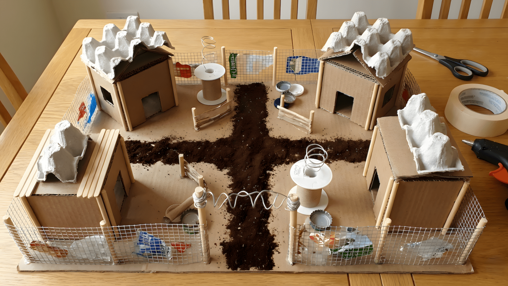 Tabletop RPG terrain diorama built from cardboard, household materials, and reused packaging.